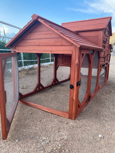 A red wooden chicken coop for 4+ chickens set outdoors with a partly cloudy sky in the background.