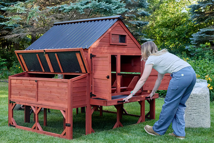Red wooden chicken coop featuring a large pull-out metal tray for easy cleaning and waste management.