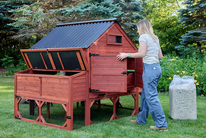 Large red chicken coop with easy-access double doors and flip-up nesting box lid for quick cleaning.